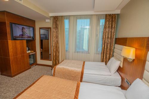 a hotel room with two beds and a flat screen tv at Akman Premium Hotel in Ankara