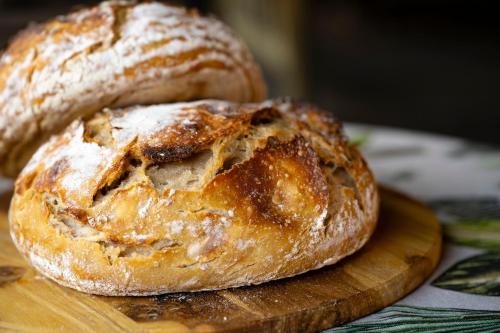 two loaves of bread sitting on a wooden cutting board at Woodall Country House and Spa in Addo