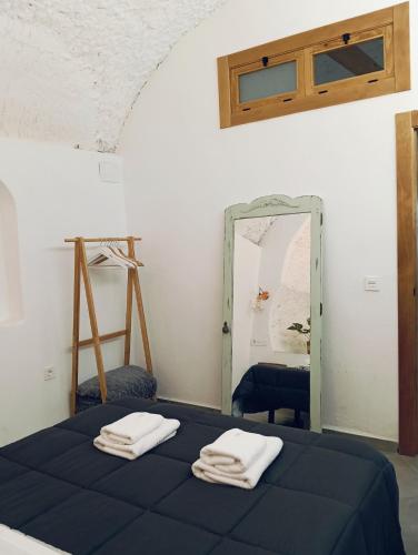 a bedroom with a blue bed and a mirror at La Madriguera Eco Caves 3 in Guadix