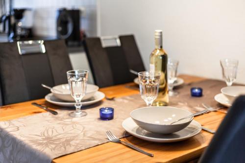 a wooden table with plates and a bottle of wine at Ferienhaus Schäferhund in Thiessow