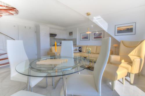 une salle à manger avec une table et des chaises en verre dans l'établissement Windeby 1D, à Wenningstedt