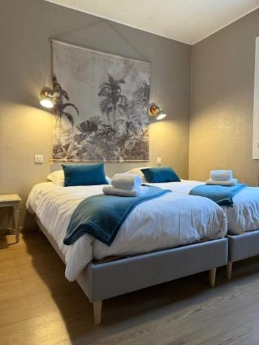 une chambre avec deux lits et un tableau au mur dans l'établissement Piscine chauffée-Beauval et Châteaux-, à Cormeray