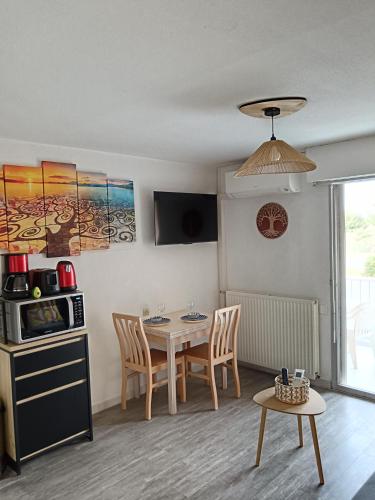 eine Küche und ein Esszimmer mit Tisch und Stühlen in der Unterkunft Balaruc studio avec piscine parking et climatisation in Balaruc-les-Bains