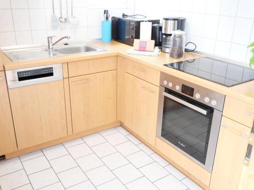 a kitchen with a sink and a stove top oven at "Blaues Haus am See mit Boot" in Warin
