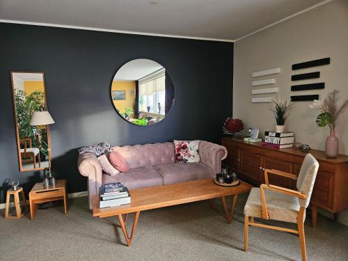 a living room with a couch and a mirror at Hótel Laugarhóll with natural hot spring in Laugarholl