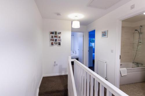 a bathroom with a staircase and a tub and a sink at Piran View in Perranporth