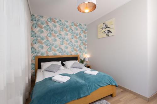 een slaapkamer met een bed met een blauwe deken bij Apartament Atena - Beskid Apartment in Szczyrk