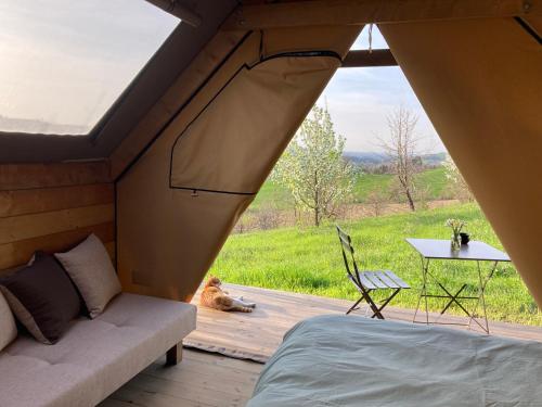 un letto e un divano in una tenda con vista di Agriturismo Glamping Pettirosso a Fratta Terme