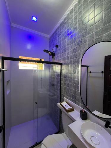 a bathroom with a shower and a sink and a mirror at La Fluorita Hospedaria in Morro do Chapéu