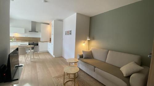 un salon avec un canapé et une cuisine dans l'établissement Appartement vue mer pour 4 personnes, à Canet