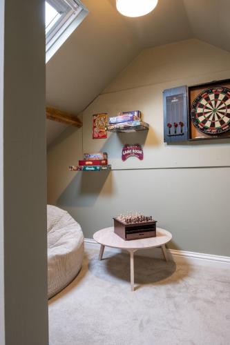 a room with a table and a dart board on the wall at Rowan Cottage Lanchester-Escape Beyond Holiday Lets in Lanchester