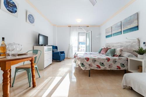 a bedroom with a bed and a table and a desk at MalagaSuite El Levante Apartments in Torremolinos