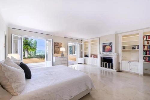 - une chambre blanche avec un grand lit et une cheminée dans l'établissement Domaine Picasso, à La Colle-sur-Loup