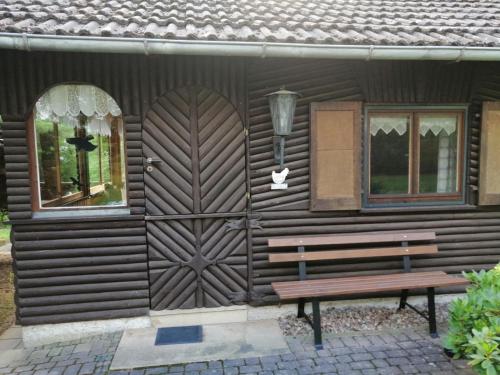 a wooden house with a wooden door and a bench at Hasenecke in Bad Salzungen