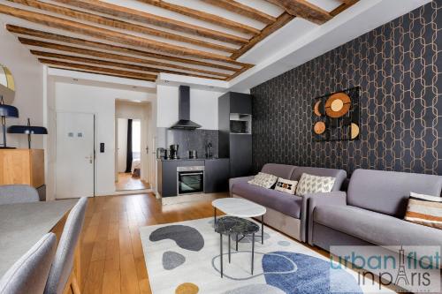 un salon avec un canapé et une table dans l'établissement Urban Flat 96 - 1 Bedroom Aboukir, à Paris