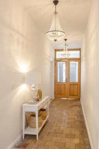 a hallway with a white table and a chandelier at Apartment No5 in Stralsund