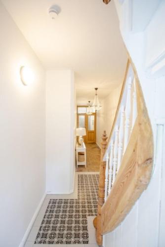 a hallway with a white staircase with a wooden hand rail at Apartment No5 in Stralsund