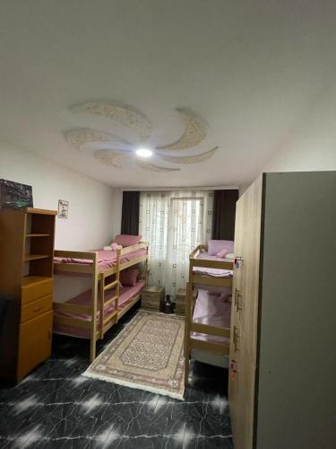 a room with four bunk beds and a ceiling at Old City Home in Prizren