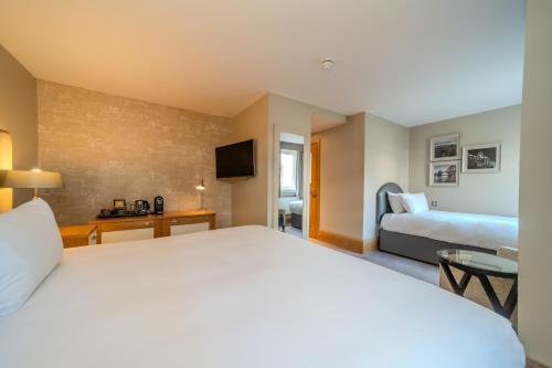 a hotel room with a large bed and a television at The Scholar in Edinburgh