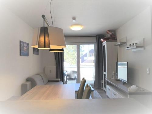 eine Küche und ein Esszimmer mit einem Tisch und einem TV in der Unterkunft Blackforest Lounge direkt an der Skipiste, inkl Parkplatz und Skiraum in Rinken