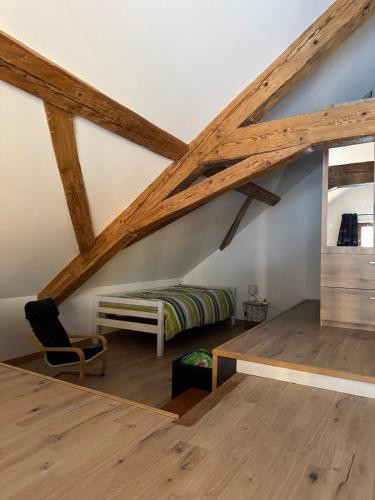 une chambre mansardée avec un lit et une chaise dans l'établissement Charmant loft de montagne Tranquilité et confort, à Thollon-les-Mémises