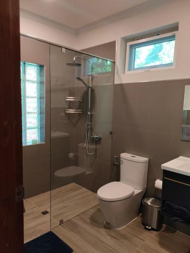a bathroom with a toilet and a shower and a sink at The Leaf Bankrut - Cosy Cottage in Ban Krut