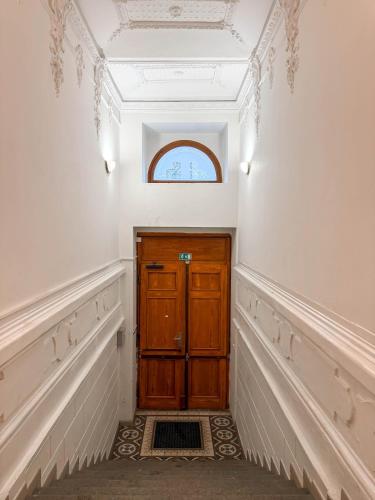 a hallway with a wooden door and a window at Radost Residence The Heart of Unique Living in Prague