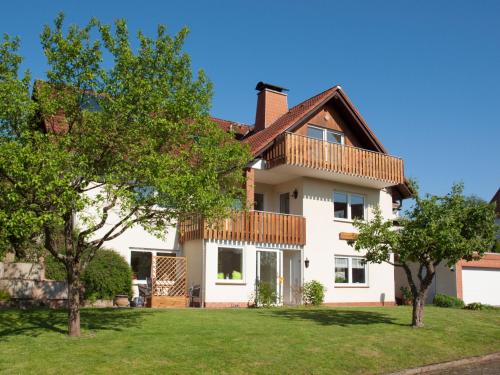 a large white house with trees in the yard at Komfortable Ferienwohnung Mit Seeblick in Bad Arolsen