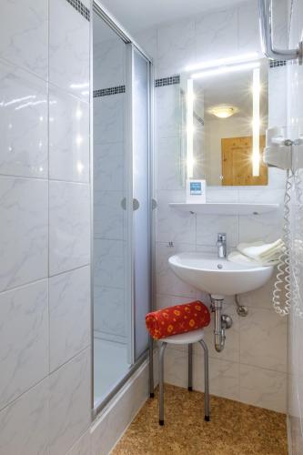 a white bathroom with a sink and a shower at Gästehaus Schlegel in Gunzesried