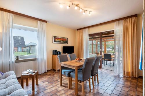 a living room with a wooden table and chairs at Ferienwohnungen Kastenmüller in Westerdeichstrich