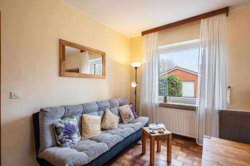 a living room with a couch and a window at Ferienwohnungen Kastenmüller in Westerdeichstrich