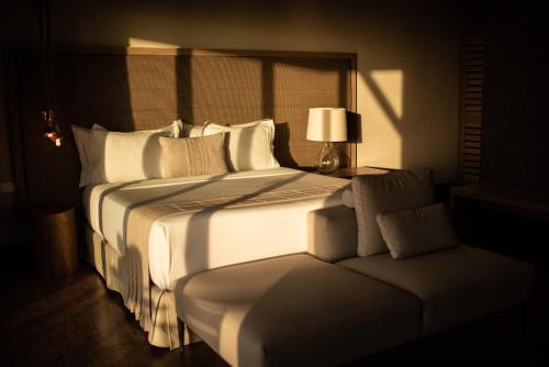 a bedroom with a large white bed and a lamp at Colina Pousada SPA in Fernando de Noronha