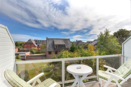 un balcon avec des chaises et une table et une vue dans l'établissement Windeby 2D, à Wenningstedt