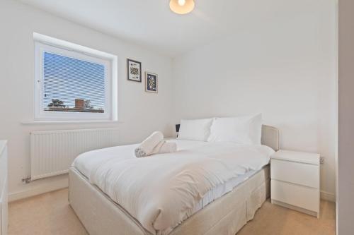 a white bedroom with a bed and a window at Spacious and Modern 2BR Stay Free Parking and WiFi in Birmingham