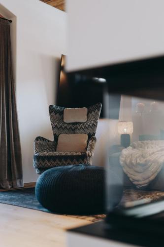 a chair sitting in a room with a table at Balma Restaurant Suites in Lech am Arlberg
