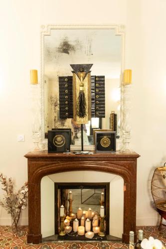 a fireplace with candles in front of a mirror at Hotel Galla Placidia in Narbonne