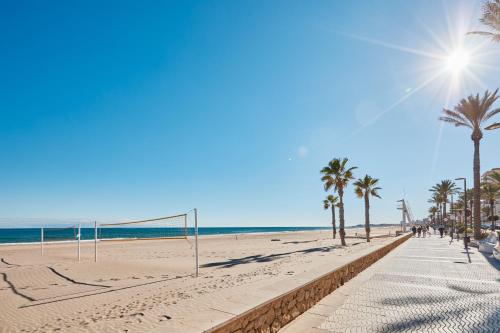 a beach with palm trees and a soccer goal at Conquistador A - by Welcomely in El Campello