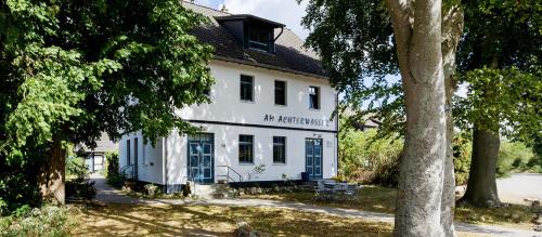a white building with blue doors and trees at Studio 52 in Rankwitz