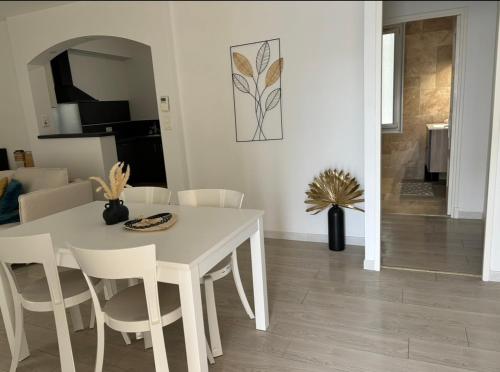 - une table à manger blanche et des chaises dans le salon dans l'établissement Appartement cosy Avignon, à Avignon