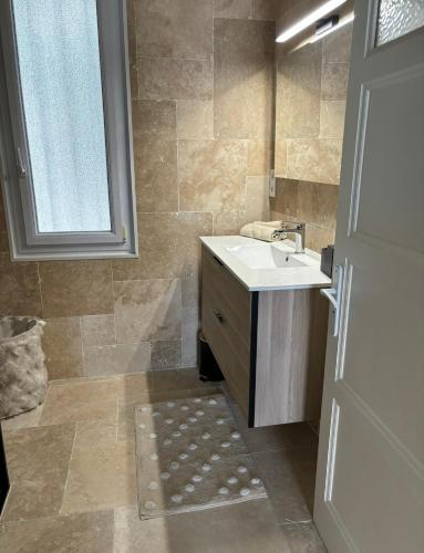 une salle de bain avec un lavabo et une fenêtre dans l'établissement Appartement cosy Avignon, à Avignon