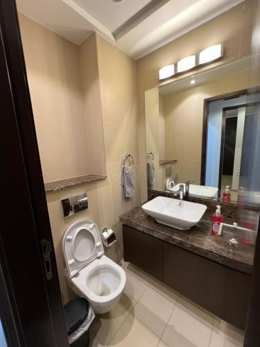 a bathroom with a toilet and a sink at Muscat bay Zaha two bedroom apartment in Bandar Jişşah