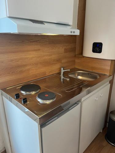 a small kitchen with a stove and a sink at Auberge Sainte Marguerite in La Garde