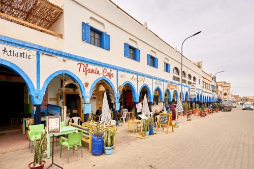 a street with tables and chairs in front of a building at Amwaj Apt - Merlift Coastal Gem Beach at Your Doorstep in Mirleft