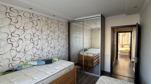 1 dormitorio con cama y pared con espejo en Три комнаты самый Центр Комрата, en Komrat