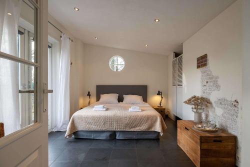 a bedroom with a large bed and a window at NEW Hello Zeeland - Cozy Country Cottage in Wissenkerke