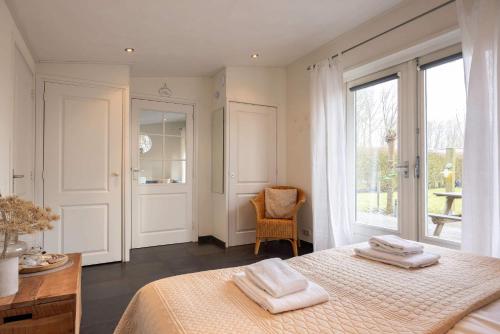 a bedroom with a bed with two towels on it at NEW Hello Zeeland - Cozy Country Cottage in Wissenkerke