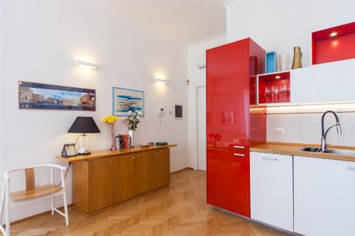 a kitchen with red and white cabinets and a desk at Don Nicola Tourist Location in Polignano a Mare