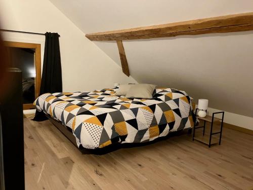 une chambre avec un lit avec une couette noire et blanche dans l'établissement Charmant loft de montagne Tranquilité et confort, à Thollon-les-Mémises