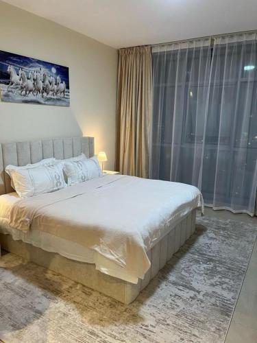 a bedroom with a large bed and a large window at Best place to stay by the sea in Ajman