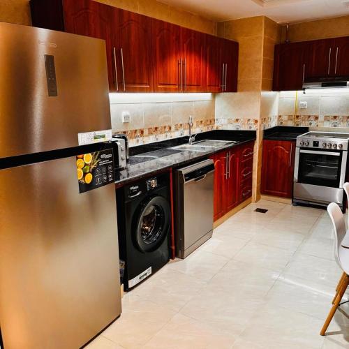 a kitchen with a stainless steel refrigerator and a dishwasher at Best place to stay by the sea in Ajman
